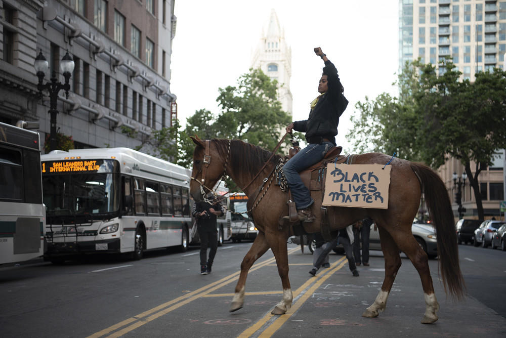 Brianna Noble riding her horse Dapper Dan in Oakland with AC Transit buses in the background