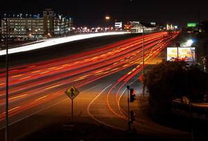 I-580 at night where car head and tail lights blur together in red and white streaks.