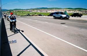 Picture of cyclists riding on the sidewalk of Tassajara Road over 580 in Dublin with cars driving in the road.