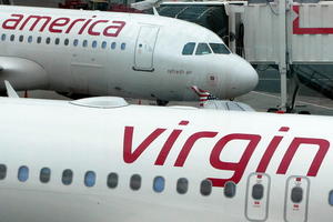 Two Virgin America A320s on the tarmac at an airport terminal.