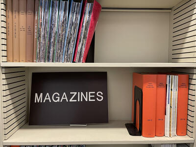 Picture of transportation magazines on a shelf with a brown sign that says "MAGAZINES"